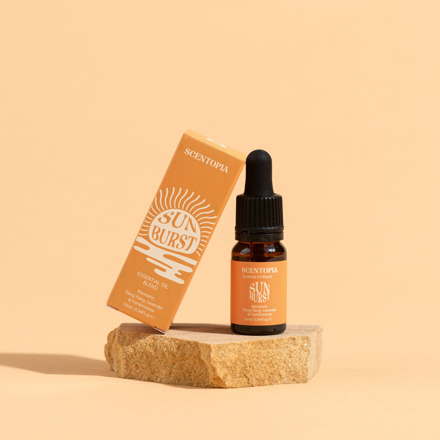 Scentopia Sunburst essential oil blend bottle and outer box on orange background