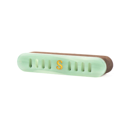 A light jade green car diffuser with a walnut wood case and a gold letter 'S' on the front, shown on a plain white background.