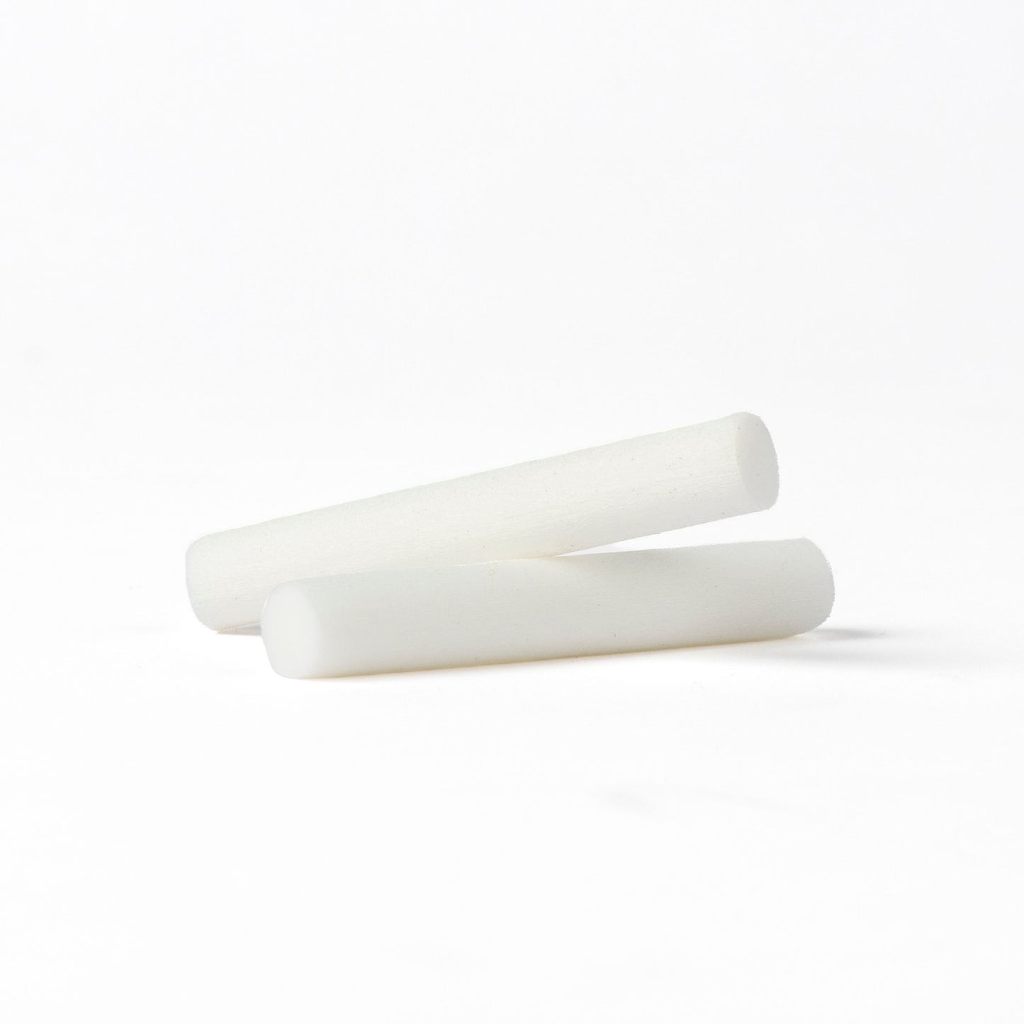 Two white cylindrical fScentopia car diffuser refill rods on a seamless white background.