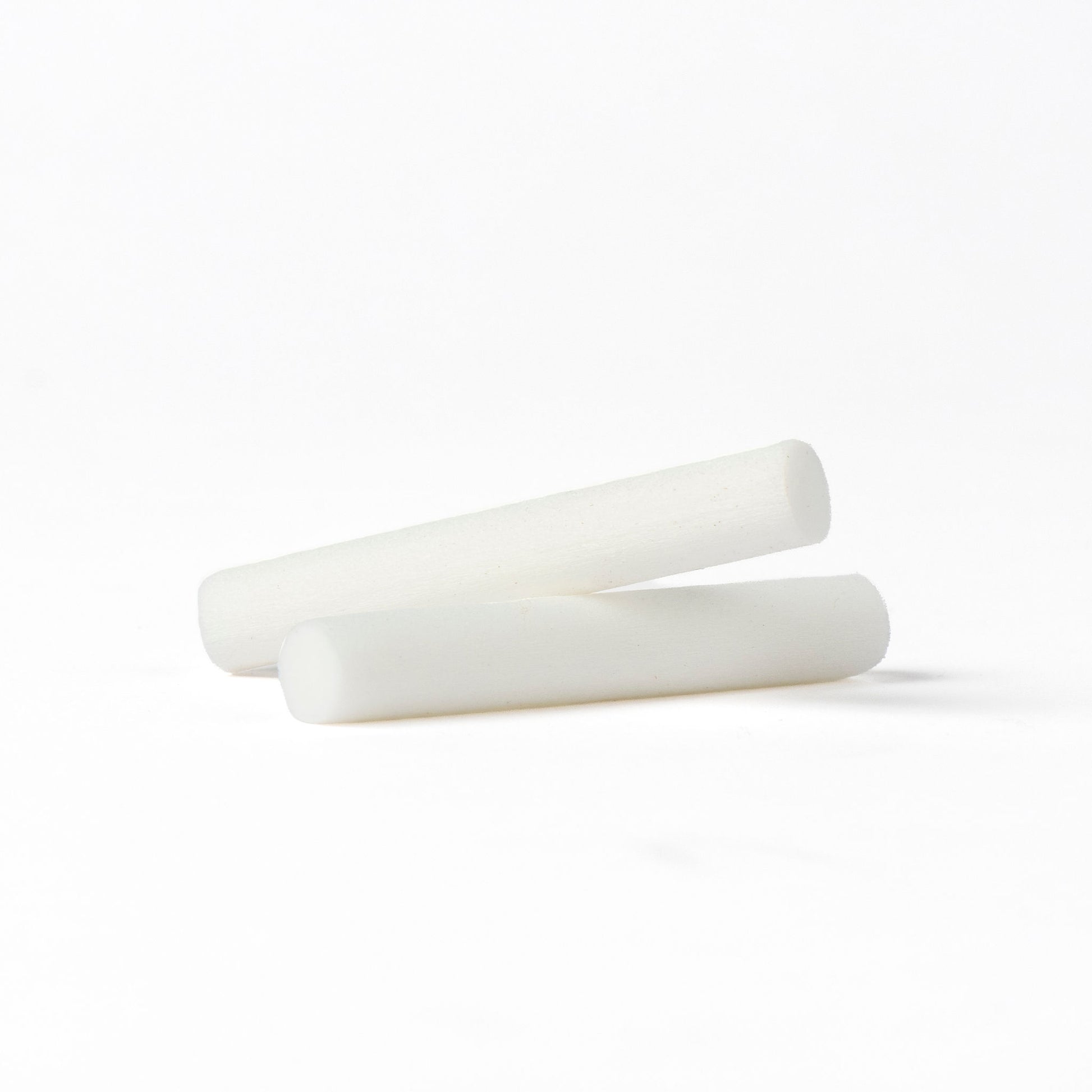 Two white cylindrical fScentopia car diffuser refill rods on a seamless white background.