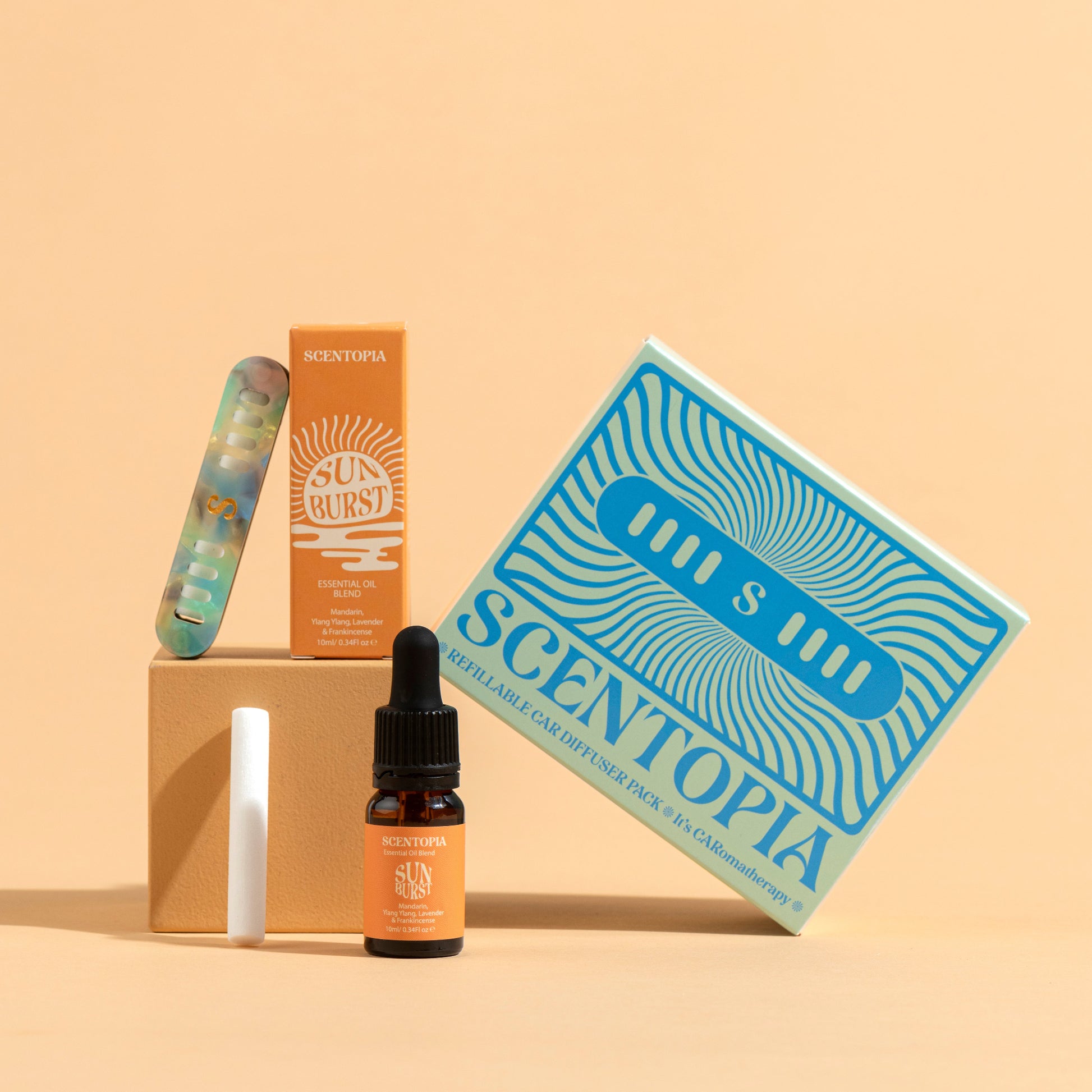 Scentopia product set including a bottle, box, and other items on a beige background