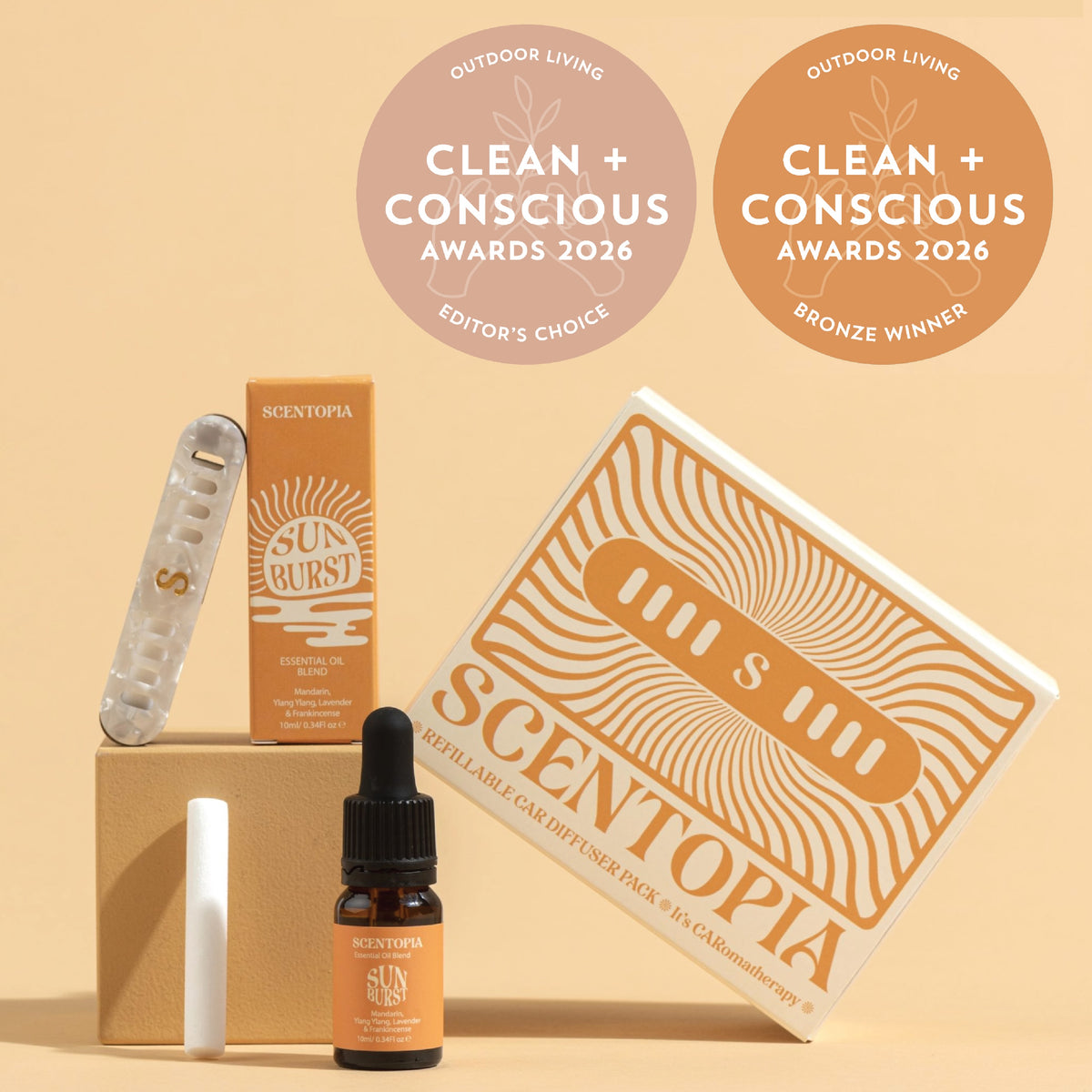 Scentopia essential oil car diffuser set with a Sunburst essential oil, and a white refill stick, arranged on a beige background with two award seals reading Clean + Conscious Awards 2026.